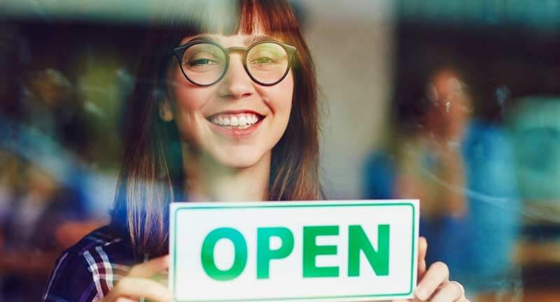 woman holding open sign