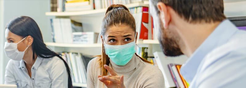 people with computers and masks for coronavirus