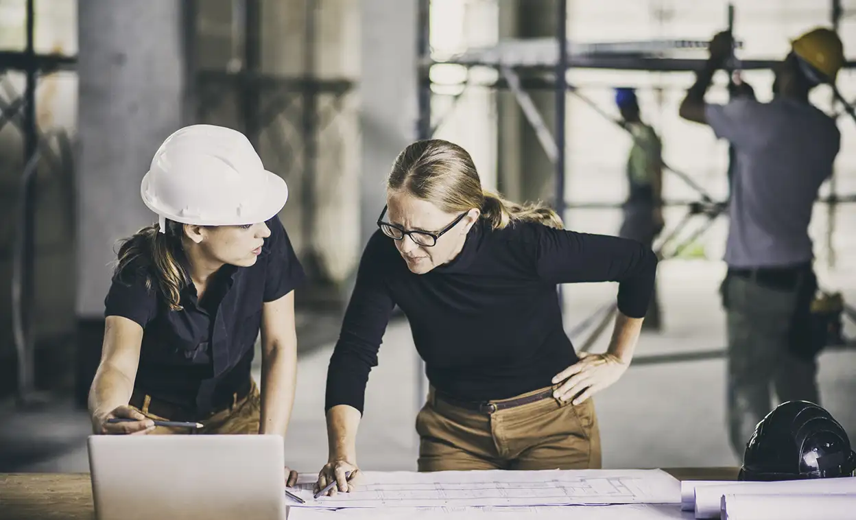 architect and construction manager reviewing building plans