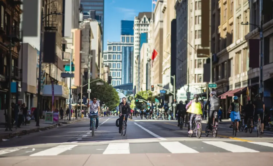 2 people biking down a street