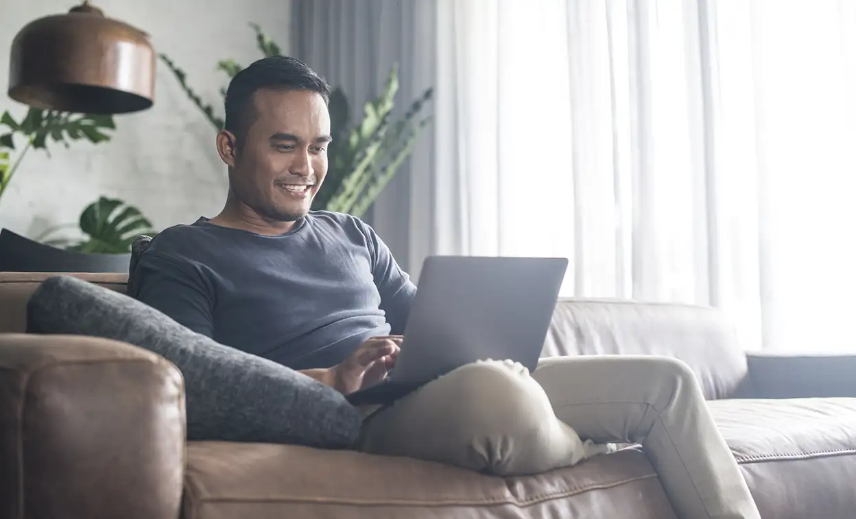 man on couch with laptop computer