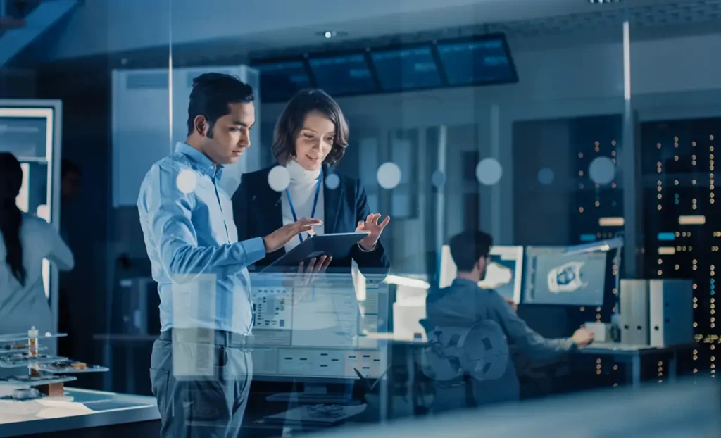 A man and woman working behind glass window