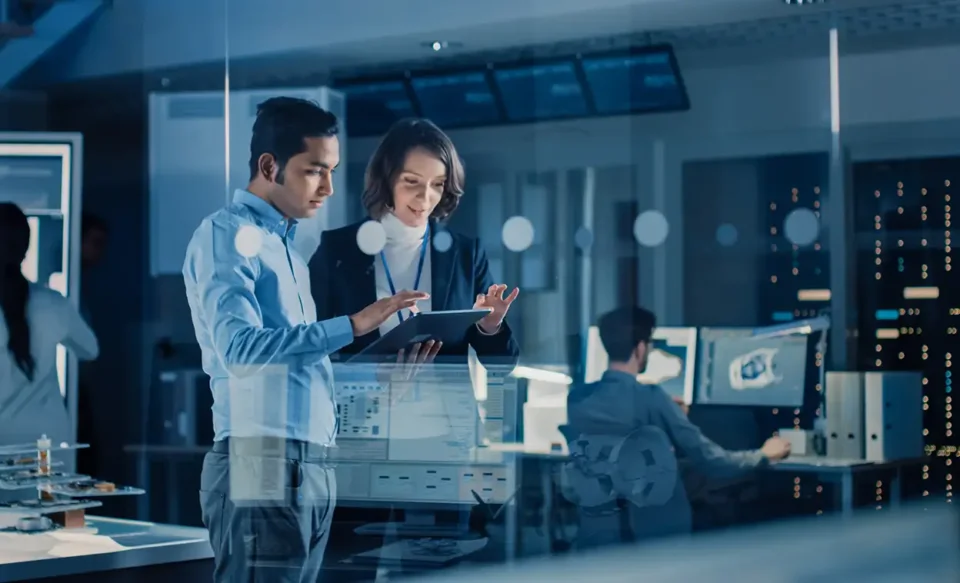 A man and woman working behind glass window