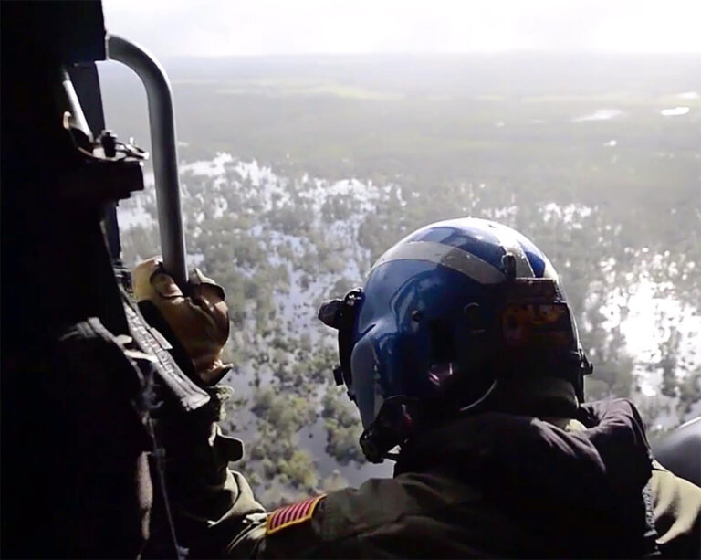 recovery specialist looking out helicopter