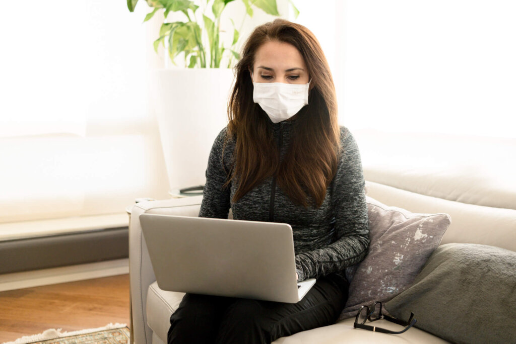 Mature woman with a mask on her working from home